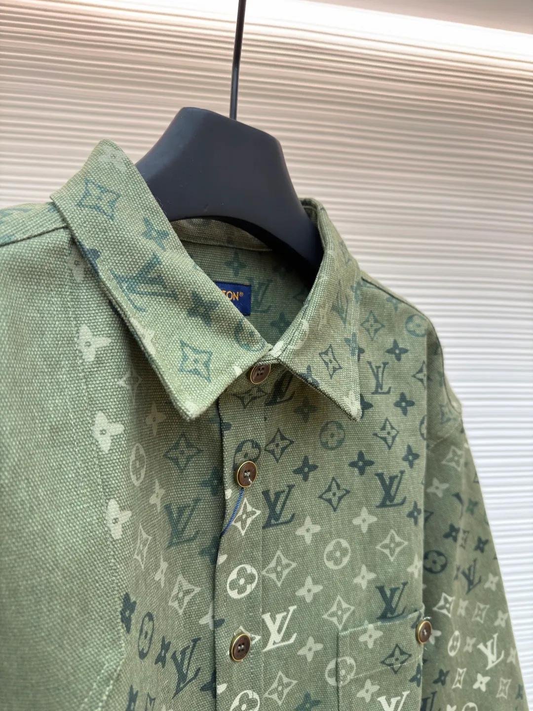 LOUIS VUITTON work jacket-style shirt with full lapel print ●Original version: Purchased and developed for 16,000 ●Item number: 1681953-B50 ●Fabric: denim fabric ●Technology: Printing ●Color: green ●Version: fitted version ●Weight: about 770 grams ●Size: S-M-L-XL ●Description: This LV lapel all-printed work jacket-style shirt adopts positioning cutting technology: before cutting the fabric pieces, the position of the all-printed Monogram pattern is locked through digital typesetting to ensure that the pattern is continuous and without misalignment after splicing, and the pattern alignment error between the body and the solid color splicing area is controlled within 0.5cm. The printing process uses digital direct injection technology: the pigment penetrates the fabric fibers with micron-sized particles, presenting a low-saturation vintage tone while maintaining the breathability of the fabric. The wear resistance of the printing layer reaches level 5 (friction test ≥ 200 times without falling off). The body is made of twill canvas blended fabric, and the splicing parts are reinforced with double-needle buried clip technology. The buttons are made of brass-plated matte paint, and the stitching is made of high-tenacity nylon thread with a tensile strength of 150N. The overall process takes into account both visual integrity and practical durability. The overall wiring is straight and delicate, the fabric is comfortable and soft, and the color is consistent without color difference. It can be matched with the same style to create a fashionable look and control various occasions. Customized accessories, complete with three standards, same style for men and women!